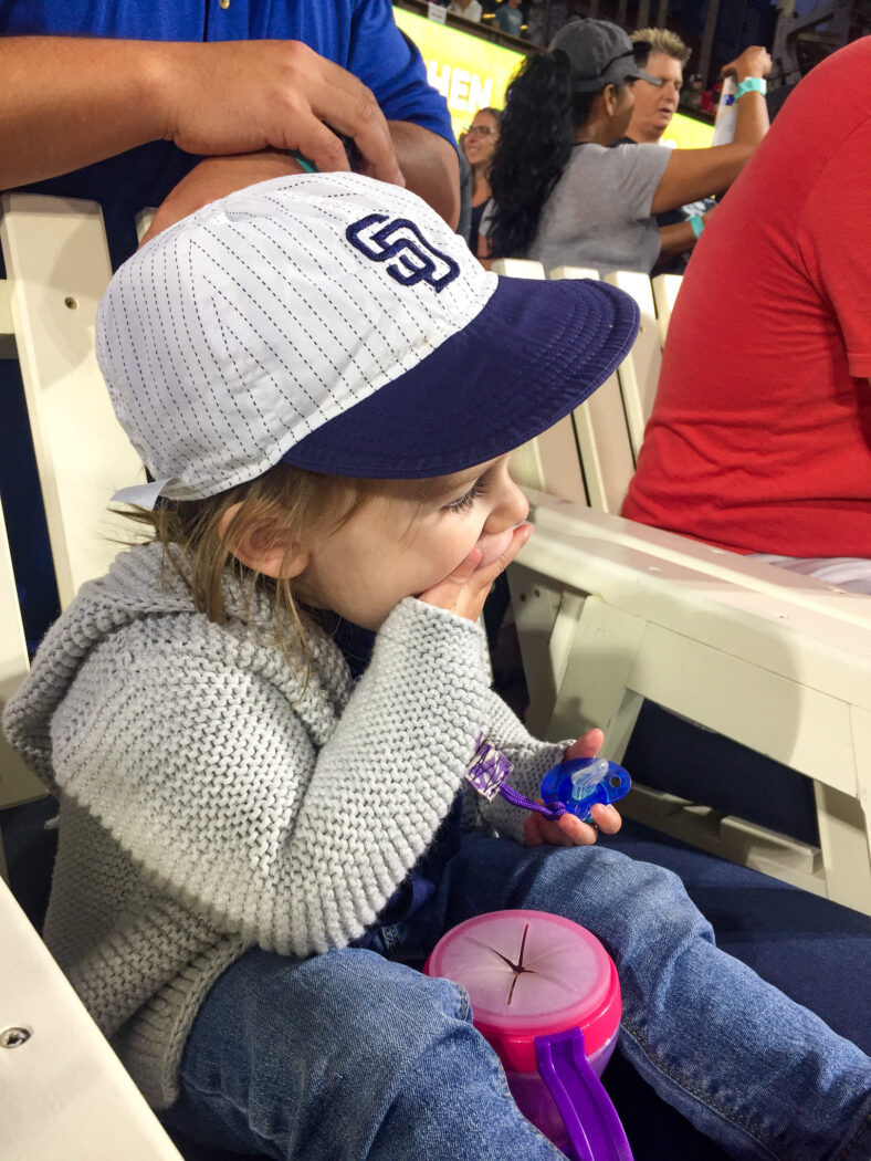 Toddler Eating Cheerios at Baseball Game
