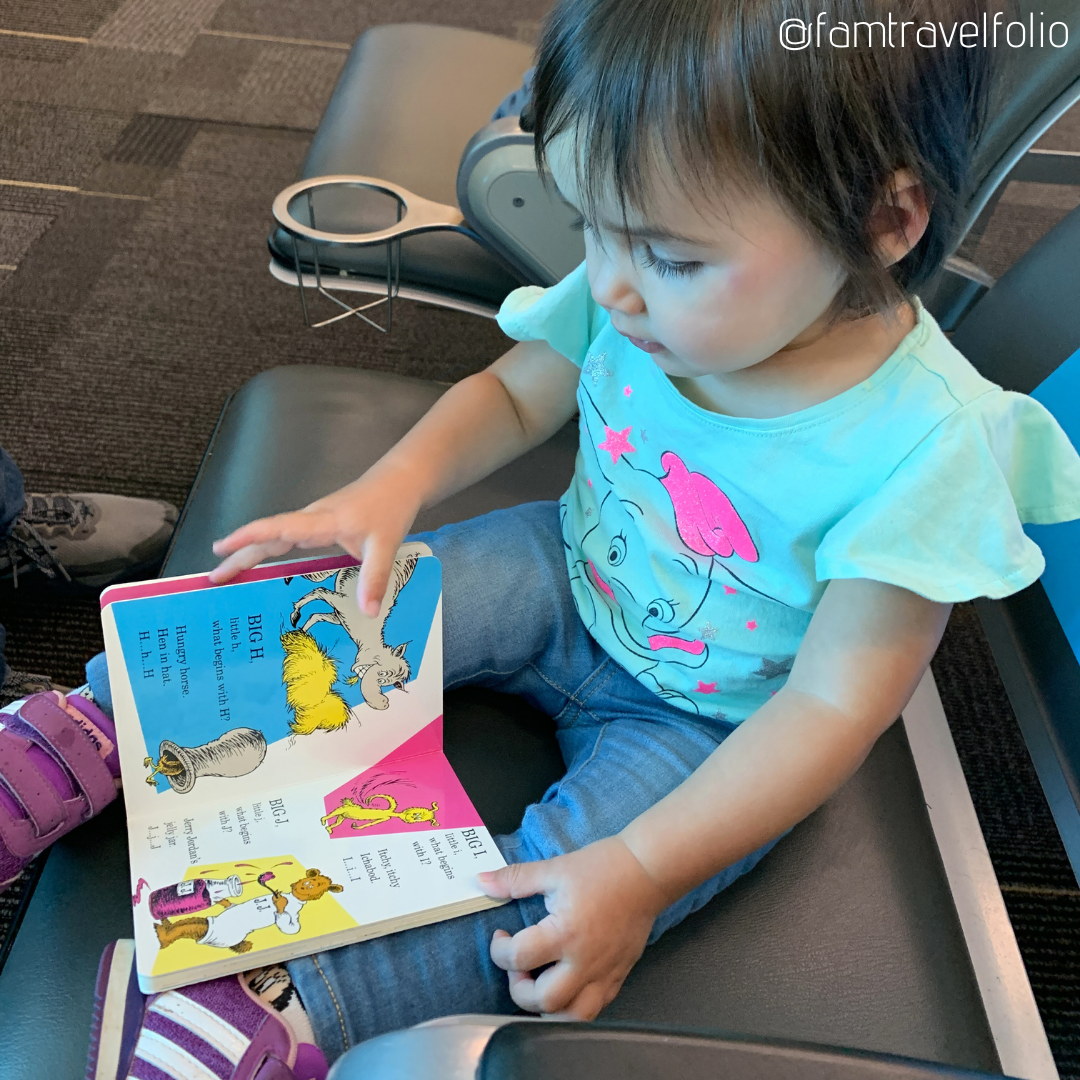 toddler reading book in airport