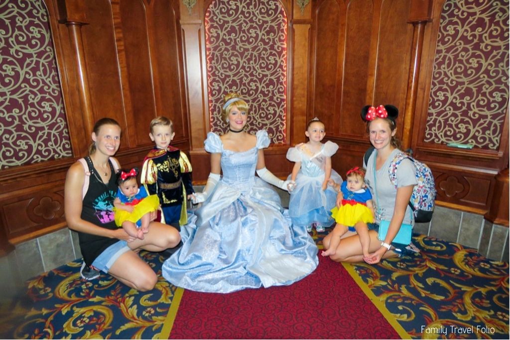 Picture with Cinderella and 2 moms (sisters) with their 2 Baby girls dressed as snow white, toddler boy dressed as a knight, and toddler girl dressed as Cinderella.