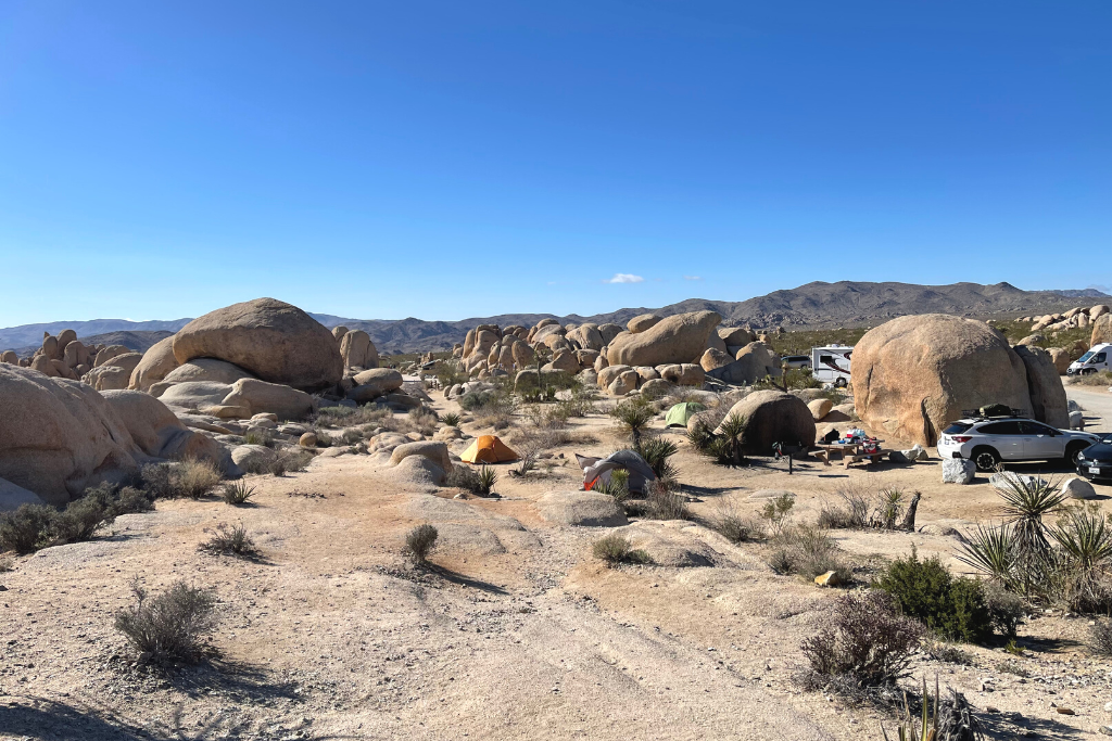 Zoomed out photo of boulder and tents at Jumbo Rocks Campground in Joshua Tree