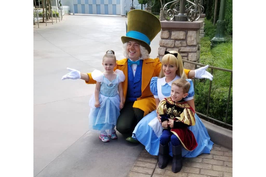 Little girl and boy dressed as Cinderella and a Knight meeting Alice in Wonderland and Mad Hatter at Disneyland