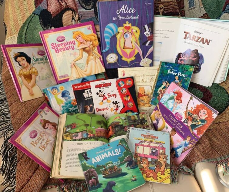 Disneyland Books for Kids Displayed on white couch with Mickey Mouse Blanket behind them