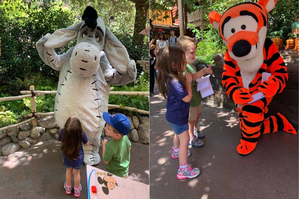 Toddler boy and girld getting autographs from Eeyore and Tigger at Disneyland