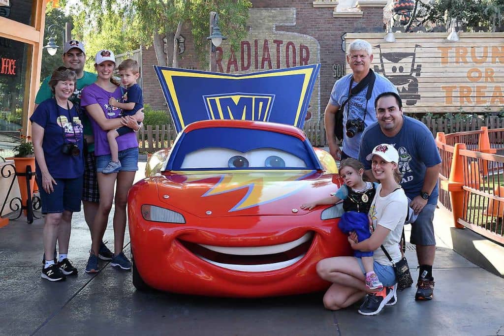 Large family on each side of Lightning McQueen at Disney California Adventure