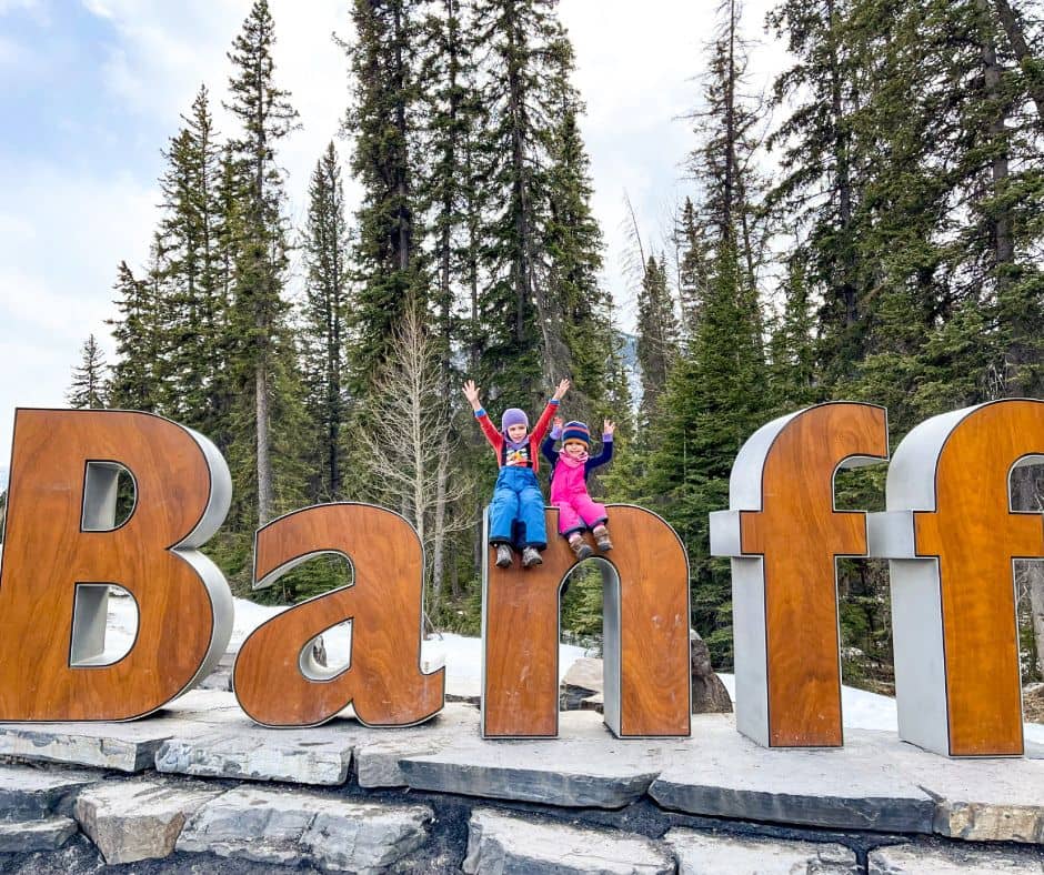 Large Banff letter sign with 2 little girls sitting on the "n"