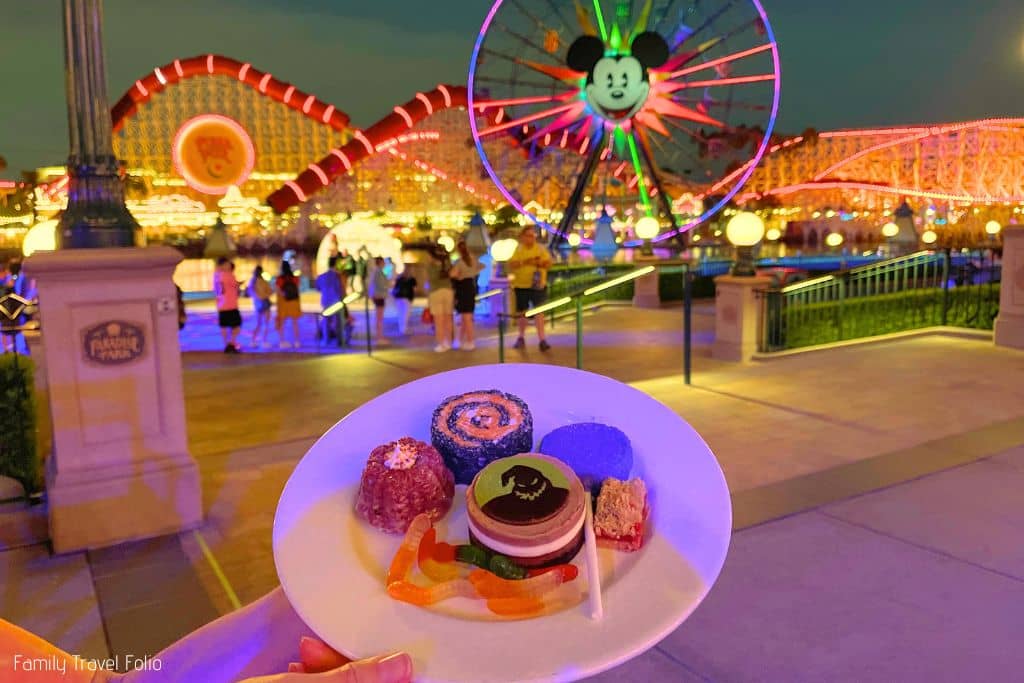 Tray of assorted desserts with Mickey's Pal-A-Round lit up in the background