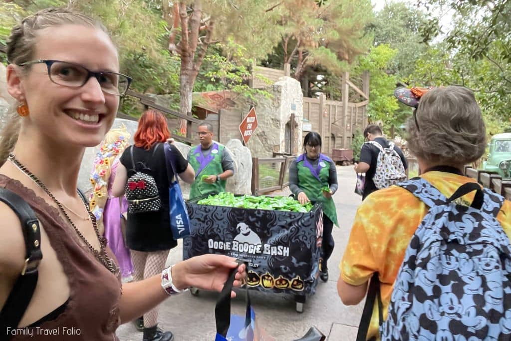 Woman holding up candy bag Trick or treating on a Disney treat trail