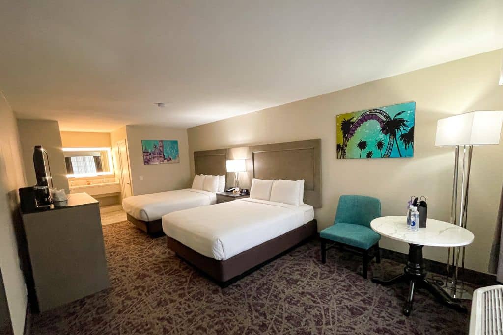 Luxury Plus Room Layout: 2 Queen Beds, table, TV, and double sink bathroom