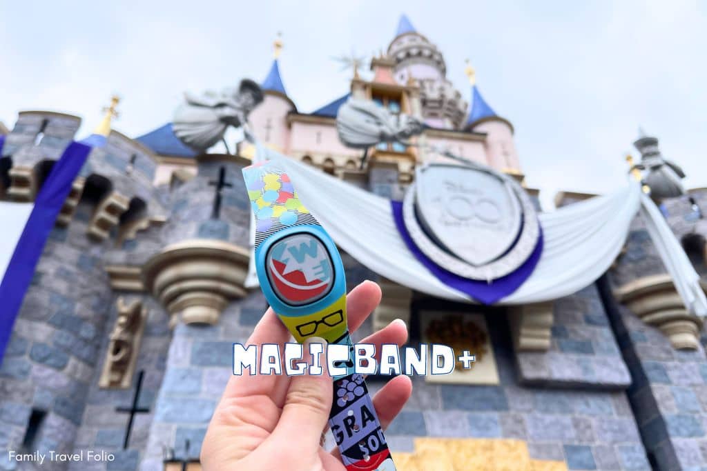 MagicBand+ Up themed being help in front of Disneyland castle