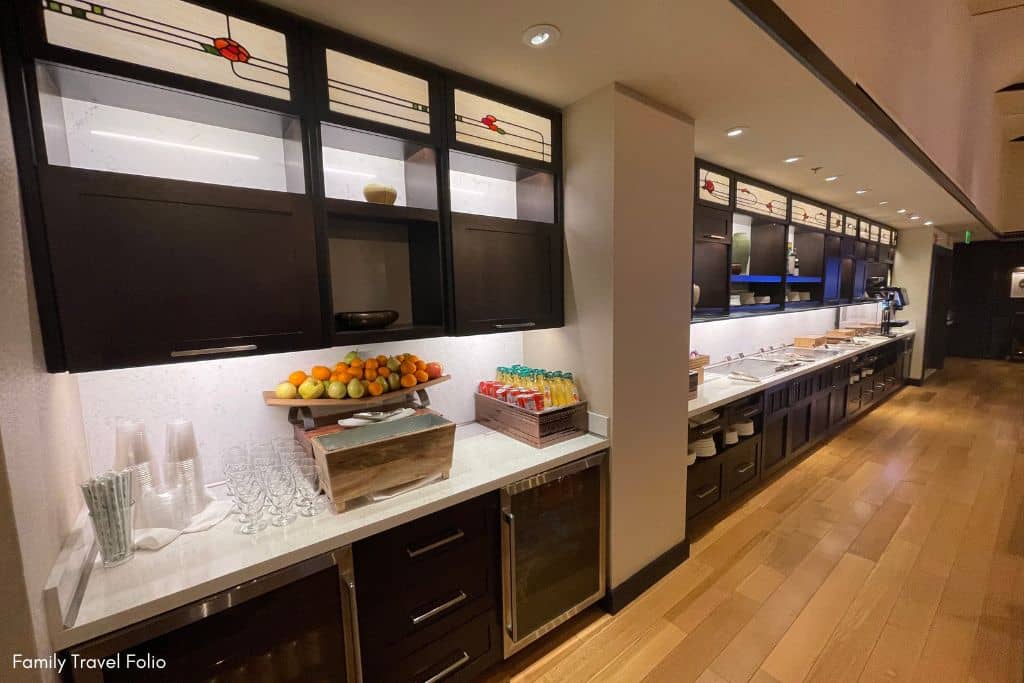 Spacious kitchenette area with stained glass cabinets and a selection of fresh fruits at the Concierge Lounge in the Grand Californian Hotel.