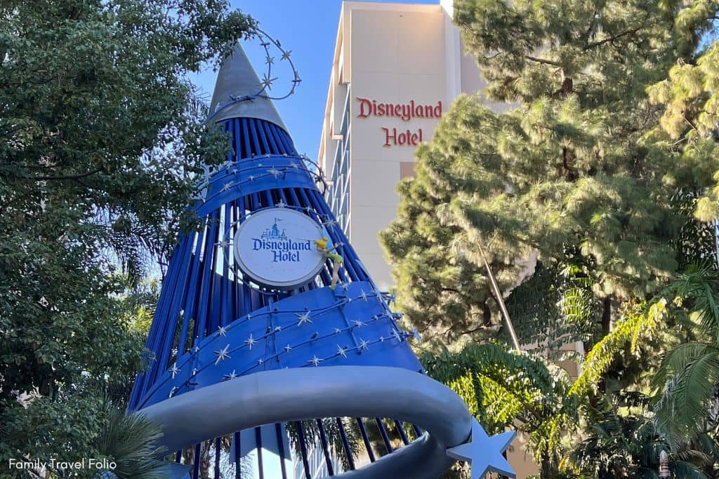 Iconic Disneyland Hotel sign with a whimsical blue sorcerer's hat against a bright Californian sky.