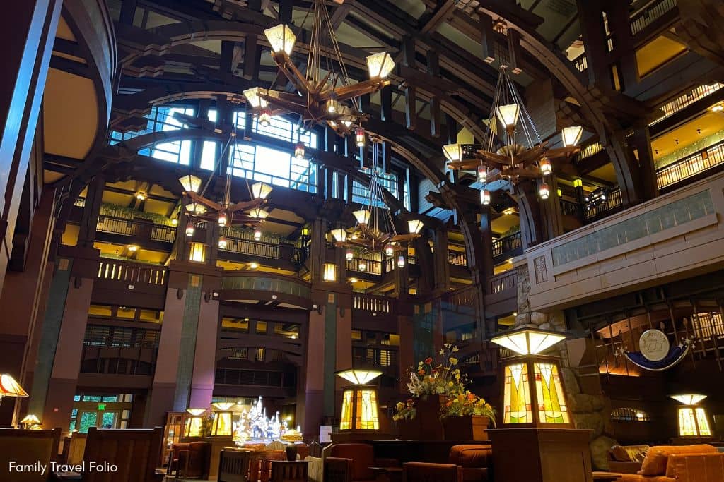 Majestic lobby of the Grand Californian Hotel with soaring ceilings, intricate woodwork, and cozy seating areas.
