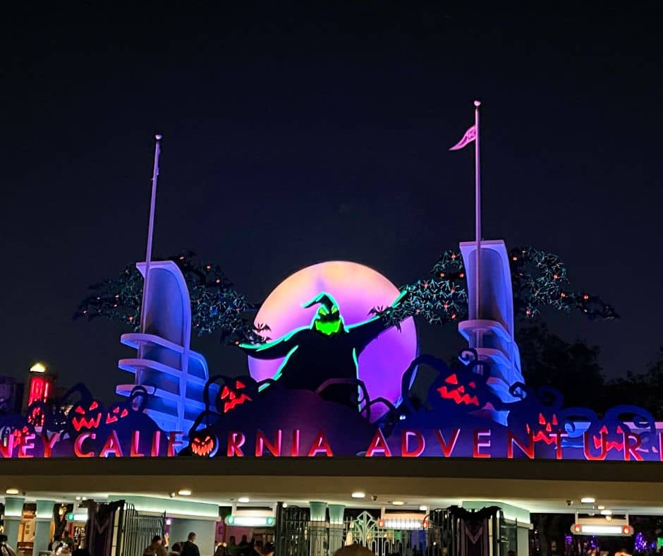 Oogie Boogie looms over the entrance of Disney California Adventure during Halloween, illuminated against a full moon backdrop, signaling the start of Oogie Boogie Bash in October.