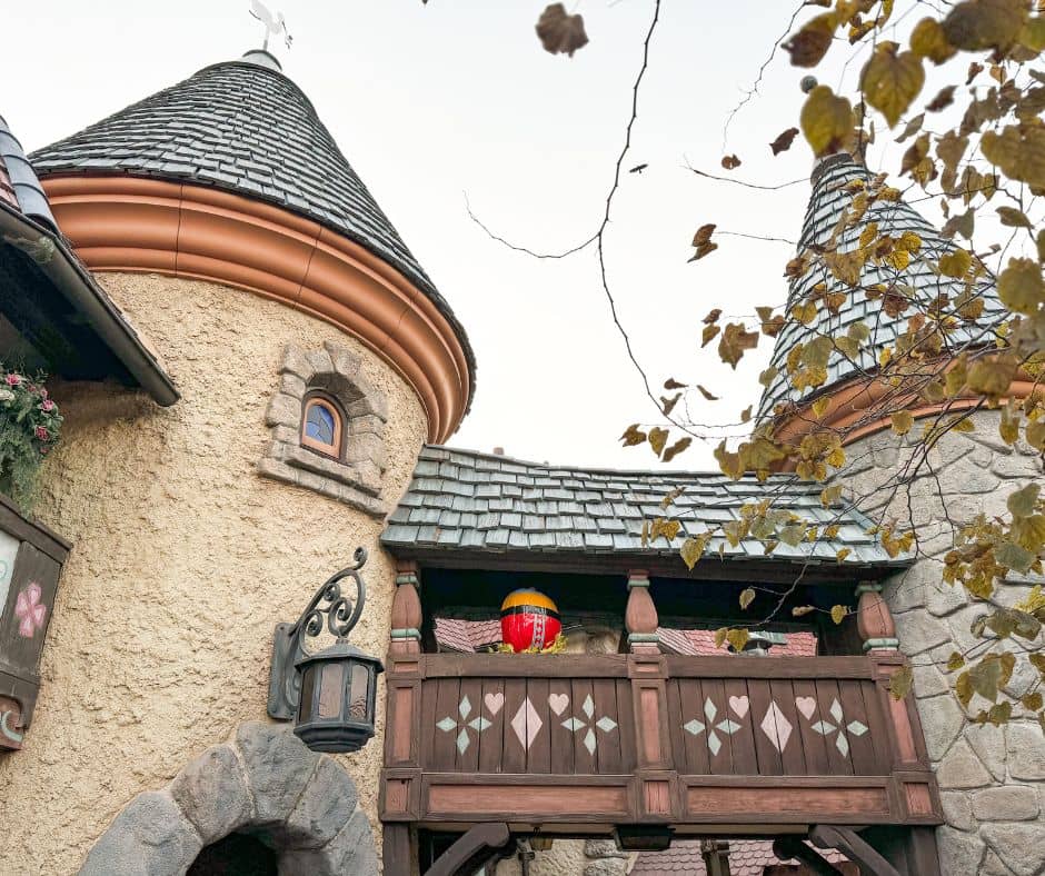 A hidden pumpkin from Pluto’s Pumpkin Pursuit nestled on a balcony at Disneyland, blending with the whimsical architecture of Fantasyland.