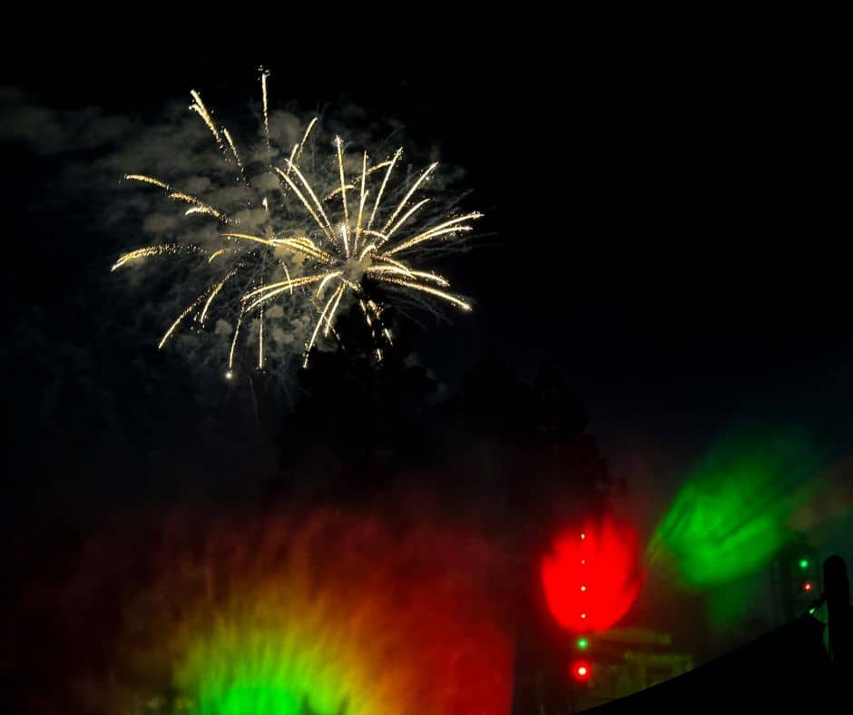 A dazzling display of Halloween Screams fireworks lighting up the night sky, accompanied by colorful projections during Disneyland’s Halloween celebration.