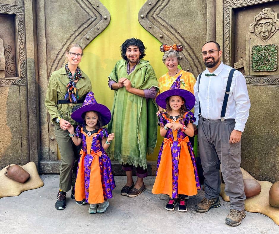 Family dressed in Halloween costumes posing with Bruno from Disney's 'Encanto' during Oogie Boogie Bash at Disneyland in October.