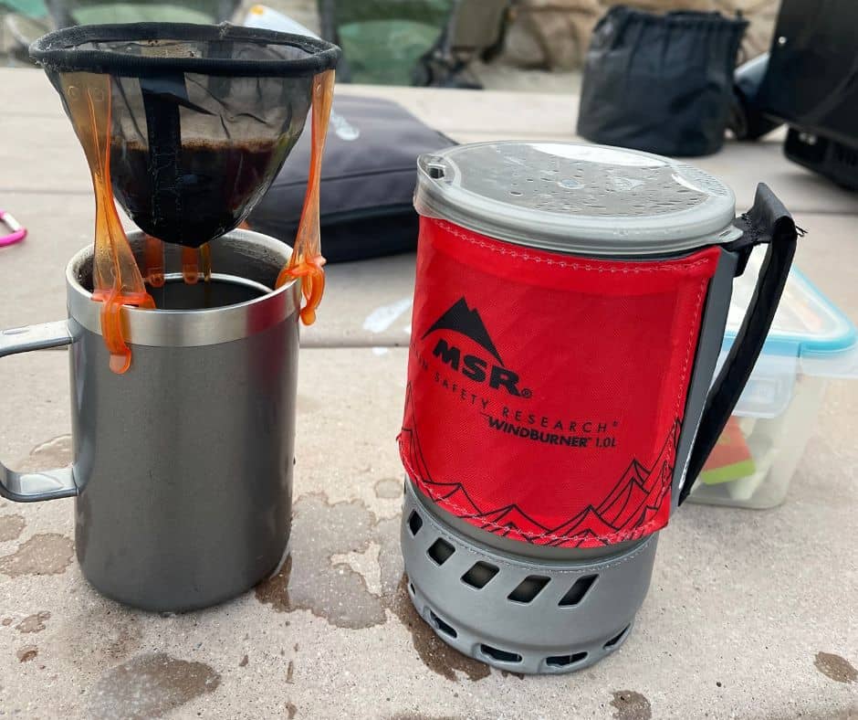 Pour-over coffee setup next to an MSR WindBurner stove during a cold-weather camping trip.