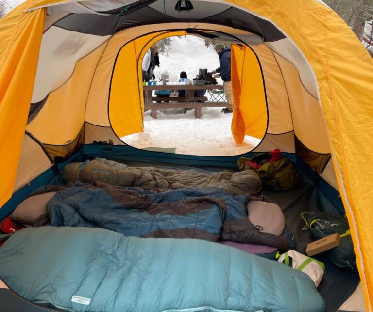 Inside view of a tent with sleeping bags and gear, showing a warm setup for cold-weather camping.