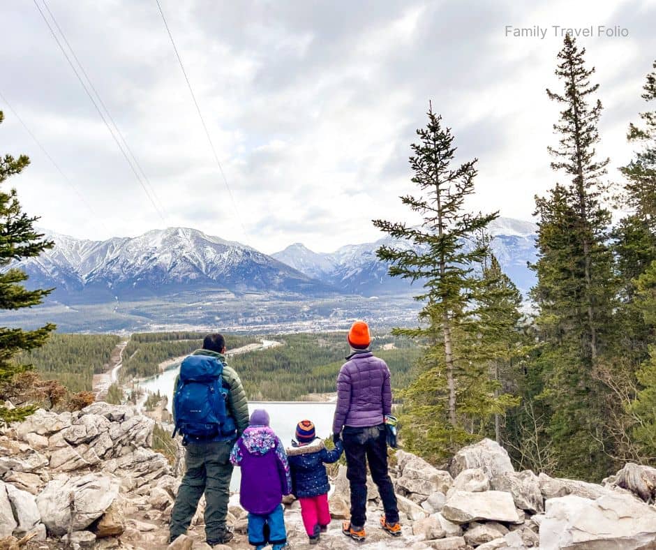 Family of four looking out over a scenic mountain view during a kid-friendly hike