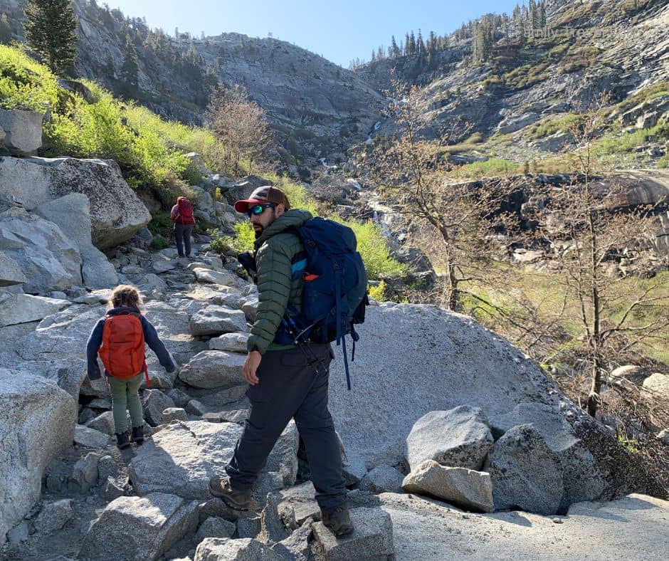 Dad and kids hiking a rocky trail in Sequoia National Park with backpacks and gear