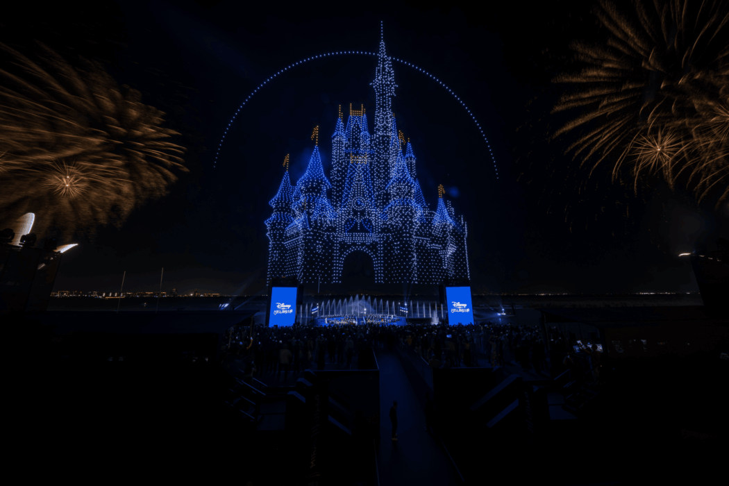 Nighttime drone light show forming a Disney castle above the Abu Dhabi coastline during the announcement event.