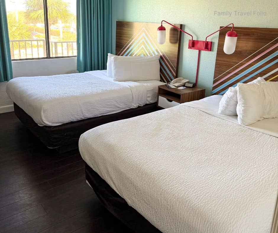 Two double beds in budget hotel room – Affordable family accommodation option for vacation budgeting.